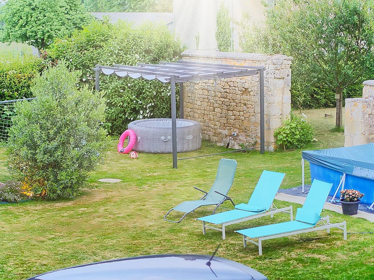 Jacuzzi spa sous pergola avec transats, piscine en arrière-plan