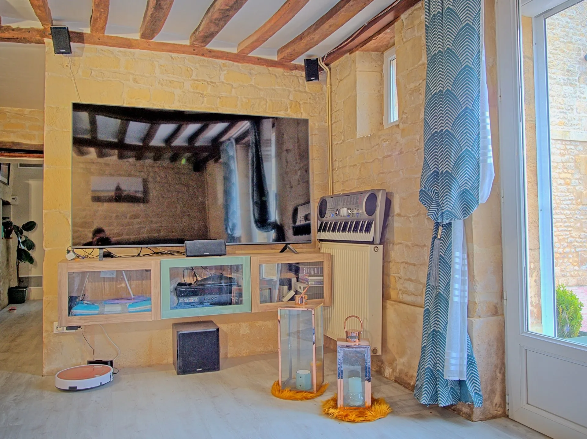 Home cinéma avec grand écran sur mur en pierre apparente